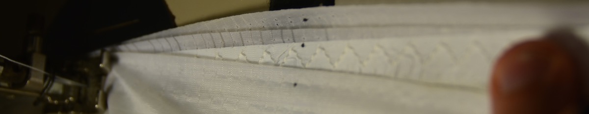 sewing a paraglider repair - this image shows 4 layers lining up as the cell is sewn back together - alignment is shown by the black dots, called registration marks