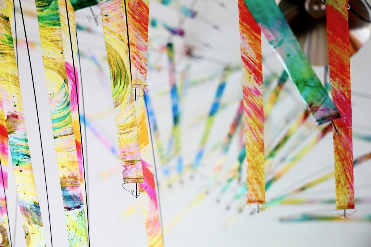Painted hand mobiles photographed from above — WindFire Designs kinetic installation