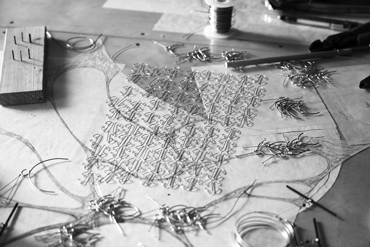 Wire and mobile parts laid out on a table in the WindFire Designs studio