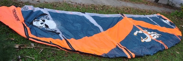 Grey and orange repair patches sewn into a Cabrinha kite, matching the original kite colors