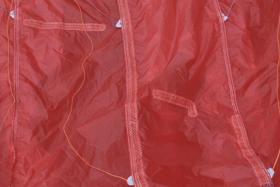 Finished internal repair on a Pro Designs paraglider wing, aligned against the factory seams