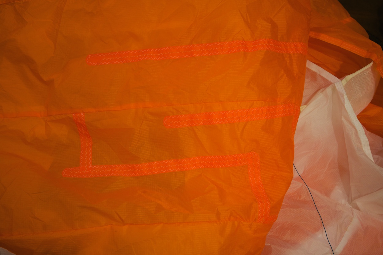Dudek Nemo paraglider repair by WindFire Designs — close-up of the patch aligned against a main wing seam