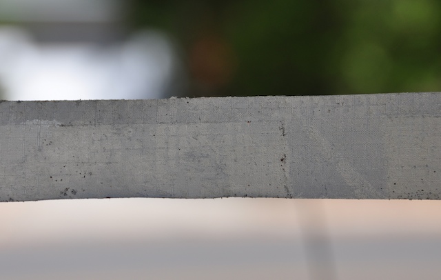 Sand gathered under a ripstop repair tape patch removed from a kite
