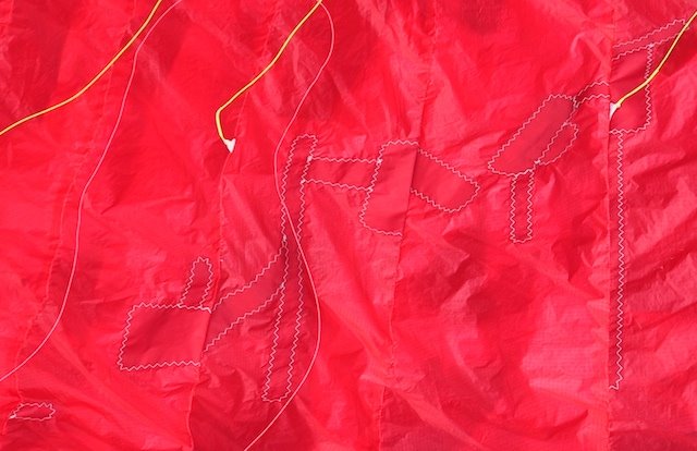 Mac Para Eden 3 paraglider cell damage with blue tape marking stitch holes on the dribs