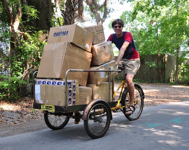 Tim Elverston riding a Worksman Frontloader tricycle loaded with boxes of repaired kites
